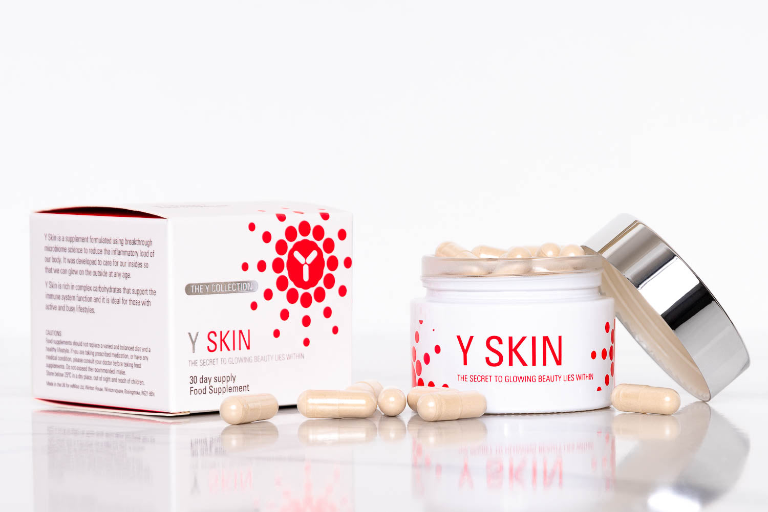 Y SKIN supplement jar and box with capsules scattered around, showcasing the product branding and packaging from The Y Collection.